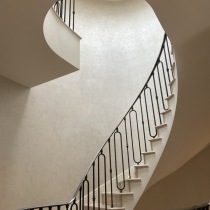 Natural light highlighting Perla polished plaster on spiral staircase walls