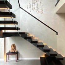 Natural light highlighting Perla Venetian plaster on walls to floating staircase
