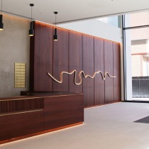 Polished plaster wall behind reception desk with strip lighting