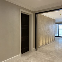 Polished plaster hallway wall with spot lighting along marble floor